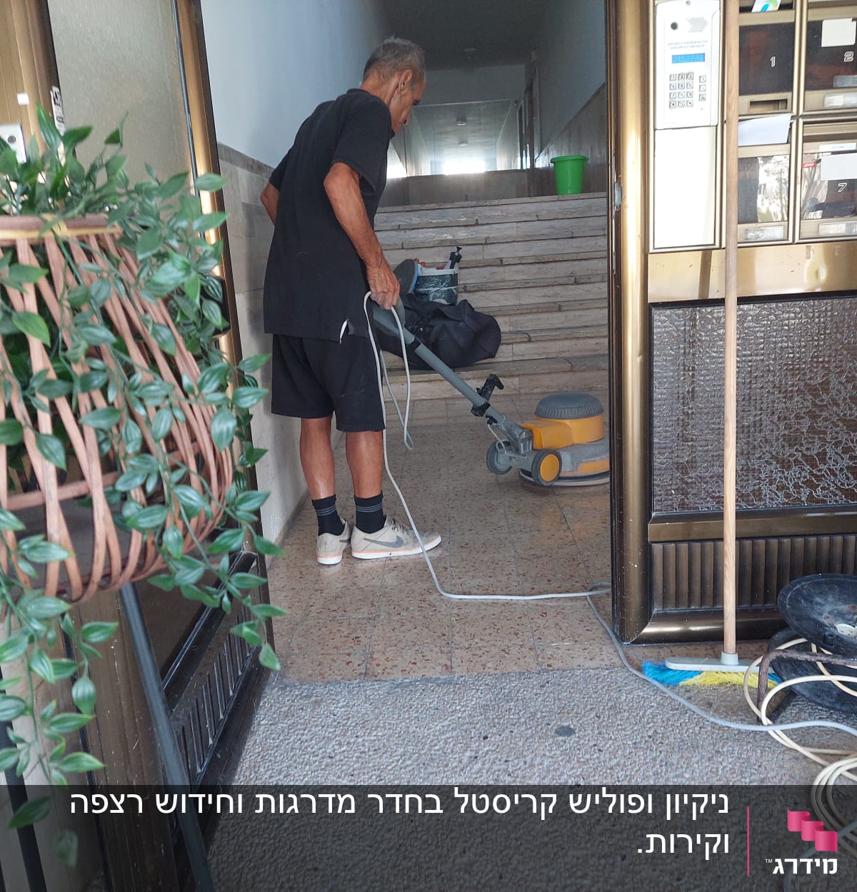 אדם מנקה רצפה עם מכונת פוליש וחוט חשמל